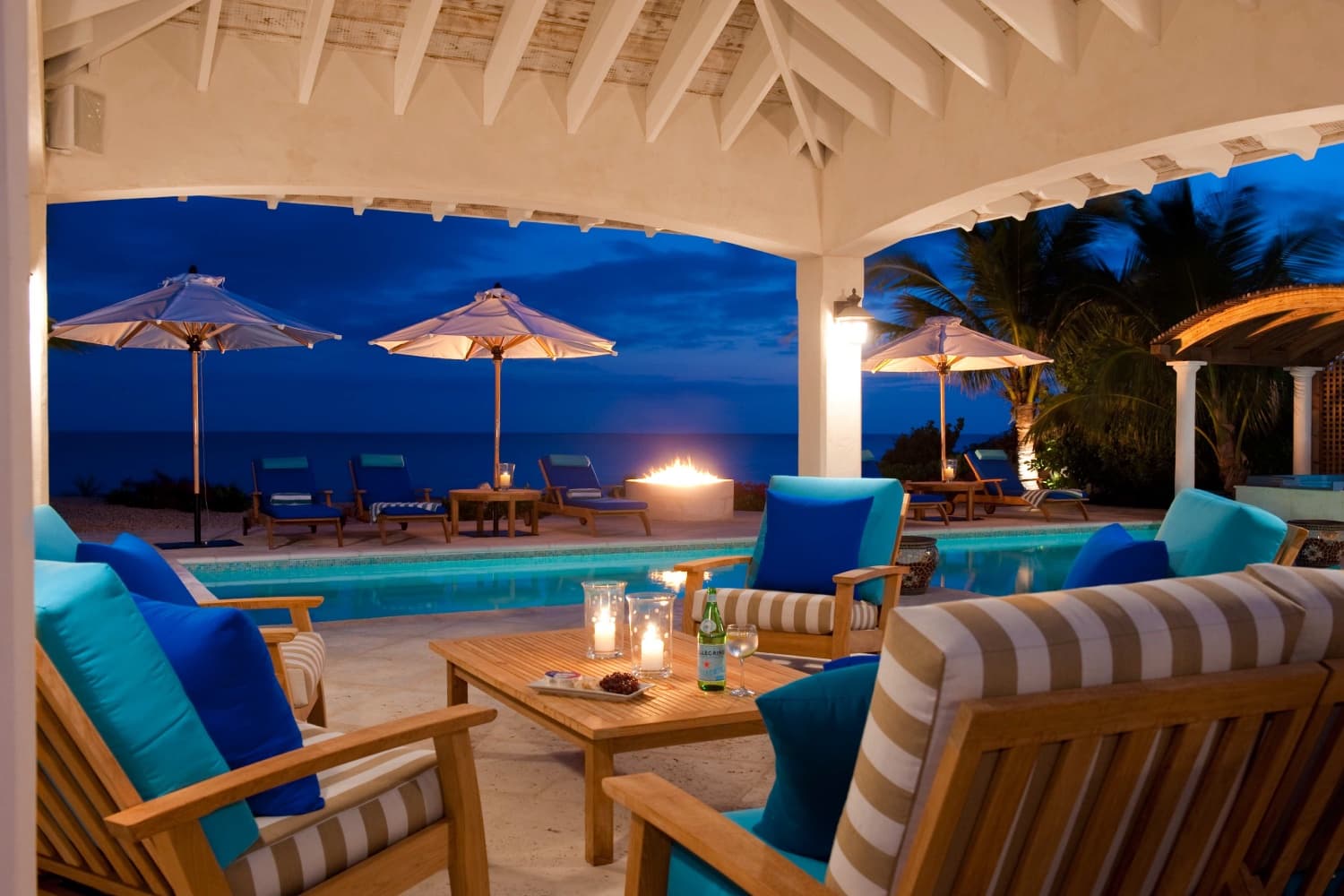 Nighttime pergola, pool and fire pit overlooking the ocean