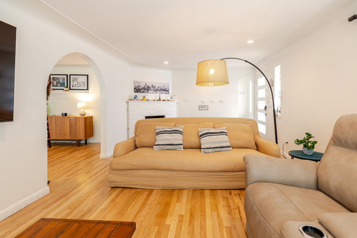 Living room with sofa, arched doorway, and hardwood floor